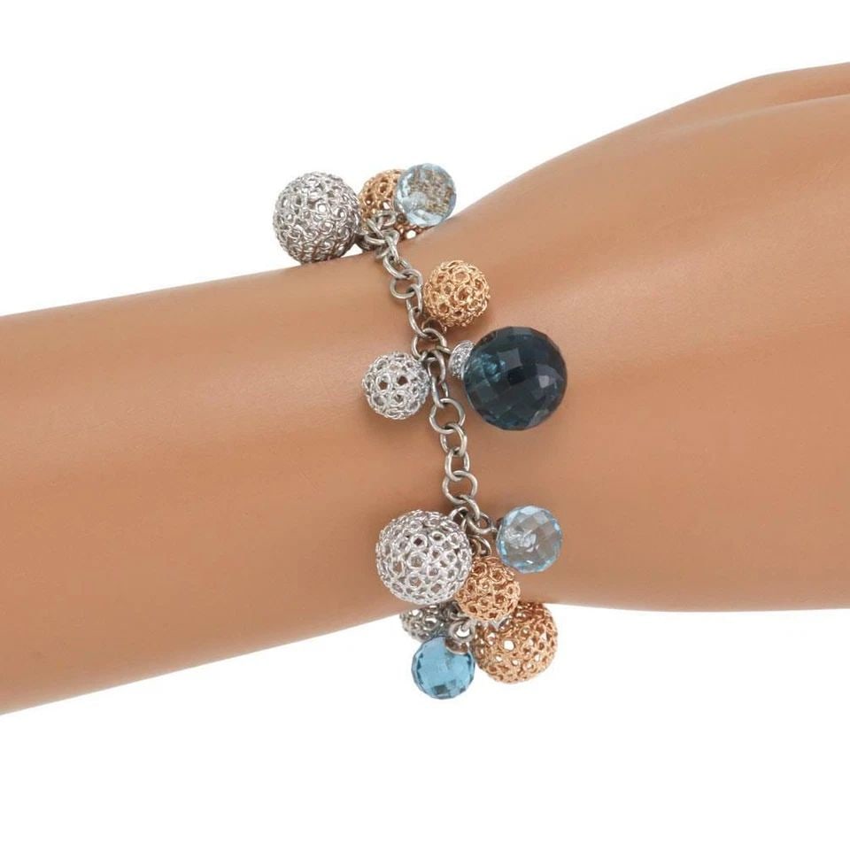 ROBERTO COIN BRACELET DIAMOND BEAD 18K GOLD FILIGREE BALL CHARMS: The Roberto Coin bracelet is a luxurious piece crafted from 18k gold with a beautiful combination of white diamonds and blue gemstones. This charms bracelet features a delicate design with intricate g