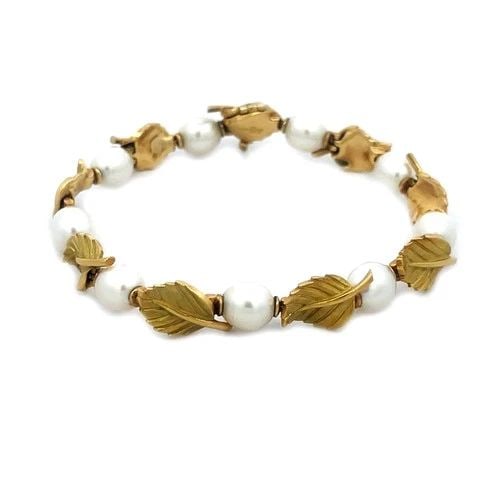 TIFFANY & CO. GOLD BRACELET 18K YELLOW OLIVE LEAF & PEARL LINK STYLE: The Tiffany & Co. Pearls Gold Bracelet is a luxurious piece of fine jewelry that features cultured white pearls set in 18k yellow gold. The pearls alternate with lovely detailed gold leaf links along 