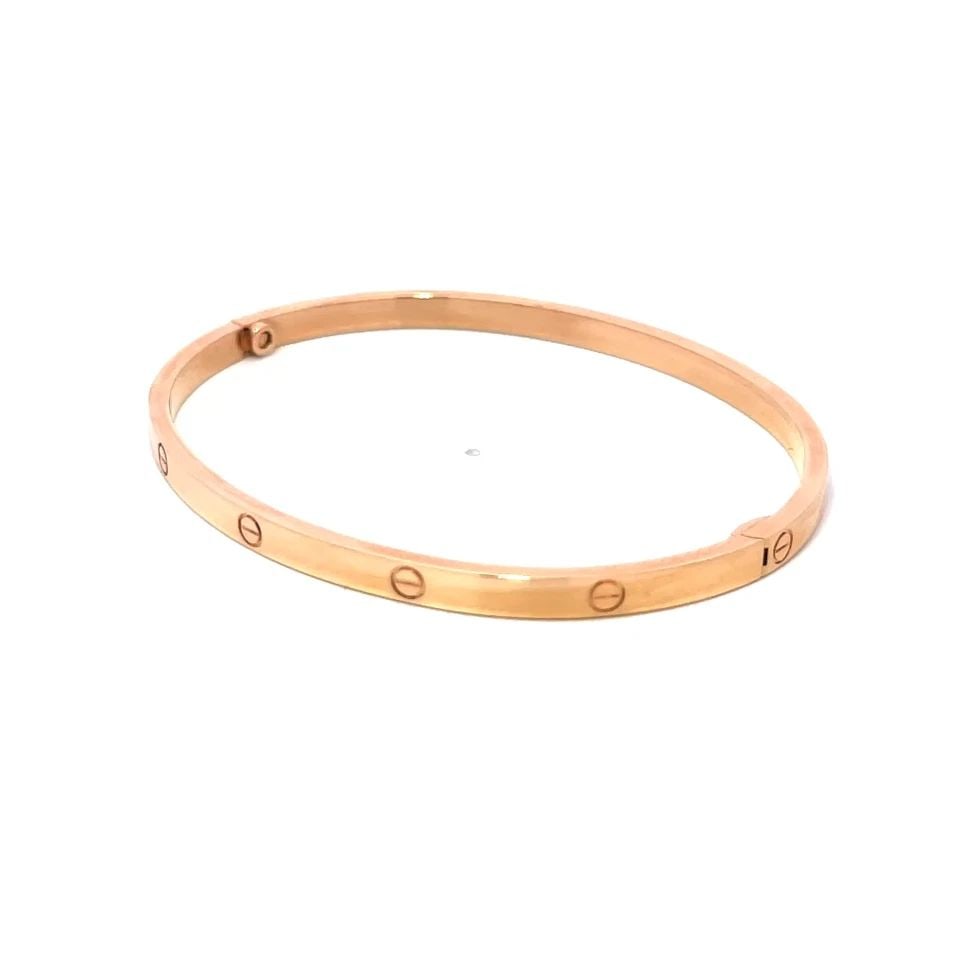 CARTIER LOVE GOLD BANGLE SMALL MODEL 18K ROSE SIZE 18 BOX & CERTIFICATE: CARTIER LOVE GOLD BANGLE SMALL MODEL 18K ROSE SIZE 18 BOX & CERTIFICATE This elegant bangle is by Cartier, from 18k rose gold, it features a screw closure and signed by the brand. This small model ban