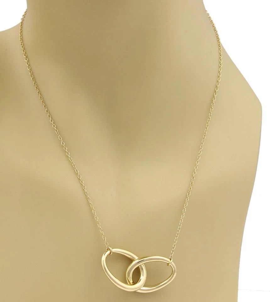 TIFFANY & CO. NECKLACE 18K YELLOW GOLD 2 INTERLACED LARGE OVAL RING PENDANT: TIFFANY & CO. NECKLACE 18K YELLOW GOLD 2 INTERLACED LARGE OVAL RING PENDANT The Tiffany & Co. Necklace is a stunning piece of fine jewelry made from 18k yellow gold. It features an interlaced large ov