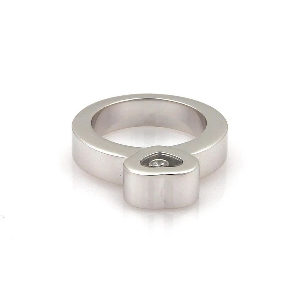 CHOPARD RING HAPPY DIAMOND 18K WHITE GOLD HEART SIZE 5.25: CHOPARD RING HAPPY DIAMOND 18K WHITE GOLD HEART SIZE 5.25 The Chopard Ring Happy Diamond in 18k White Gold is a stunning piece of fine jewelry featuring a heart-shaped band with a round natural diamon