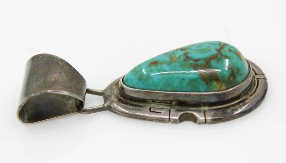 NAVAJO JERRY N PLATERO STERLING SILVER TURQUOISE PENDANT 13.8 GRAMS: NAVAJO JERRY N PLATERO STERLING SILVER TURQUOISE PENDANT 13.8 GRAMS Description Navajo Jerry N Platero Sterling Silver Turquoise Pendant The pendant is in good condition. Shows signs of wear and/or te