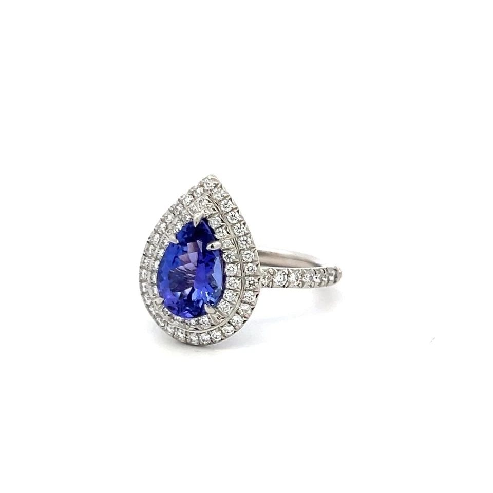 TIFFANY & CO PLATINUM ENGAGEMENT RING 0.77 CARAT DIAMONDS & 1.76 CARAT TANZANITE: TIFFANY & CO PLATINUM ENGAGEMENT RING 0.77 CARAT DIAMONDS & 1.76 CARAT TANZANITE Designer: Tiffany & Co Detailed Description: Revel in the captivating elegance of a vintage Tiffany & Co. engagement ri