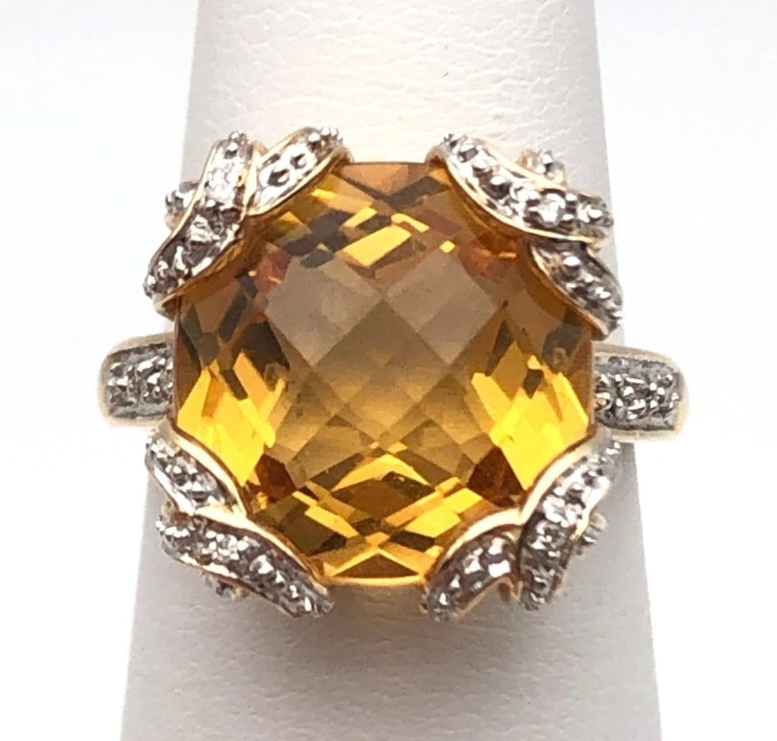 14K GOLD RING WITH 13MM CITRINE AND 0.04CTW DIAMONDS (SIZE 5.75) 6.1G: 14k Gold Ring set with 13mm Citrine and 0.04cts of Diamonds Condition: Used Material: 14k Yellow Gold Ring Size: 5.75 Weight: 6.1 grams Top Width: 15mm Bottom Width: 2mm Stone Info: Center stone is a 