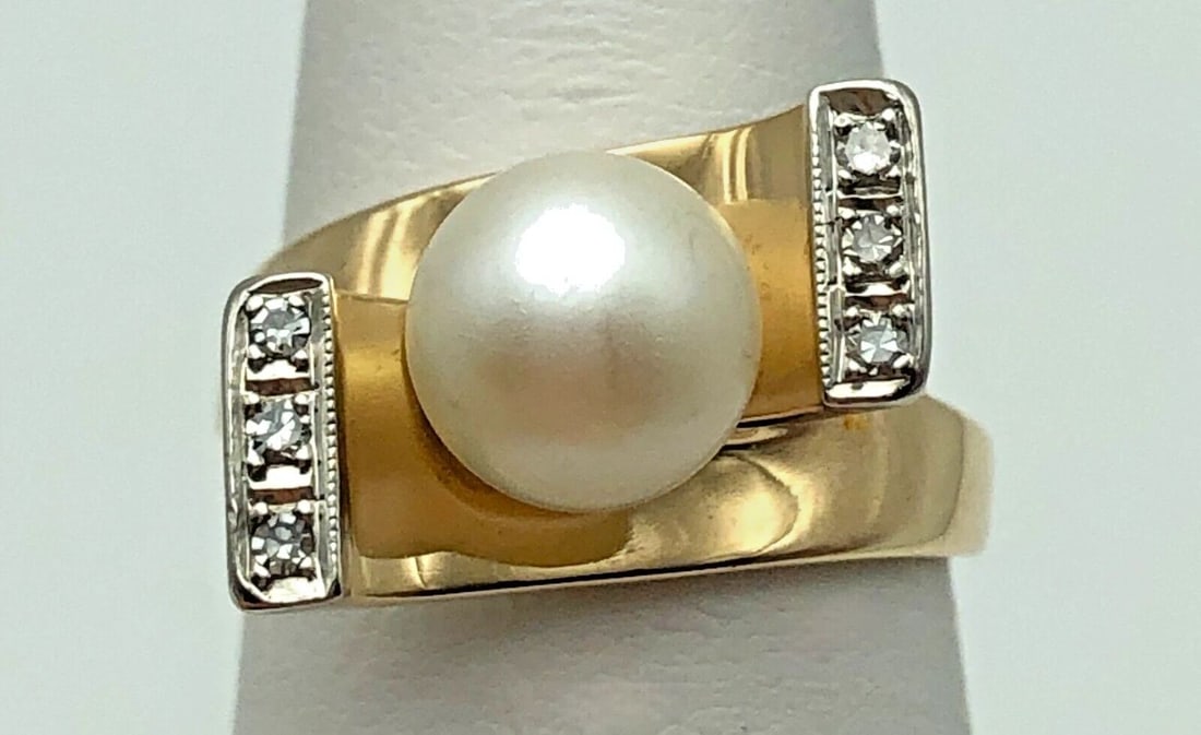 14K GOLD RING, 8MM CULTURED PEARL, 0.12CTS OF DIAMONDS ( SIZE: 7.25 ) 5.9G: 14k Gold crossing Ring, 8mm Cultured Pearl and 0.12cts of Diamonds Condition: Used, has been cleaned Material: 14k Yellow Gold Ring Size: 7.25 Weight: 5.9 grams Top Width: 10.6mm Bottom Width: 2.3mm S