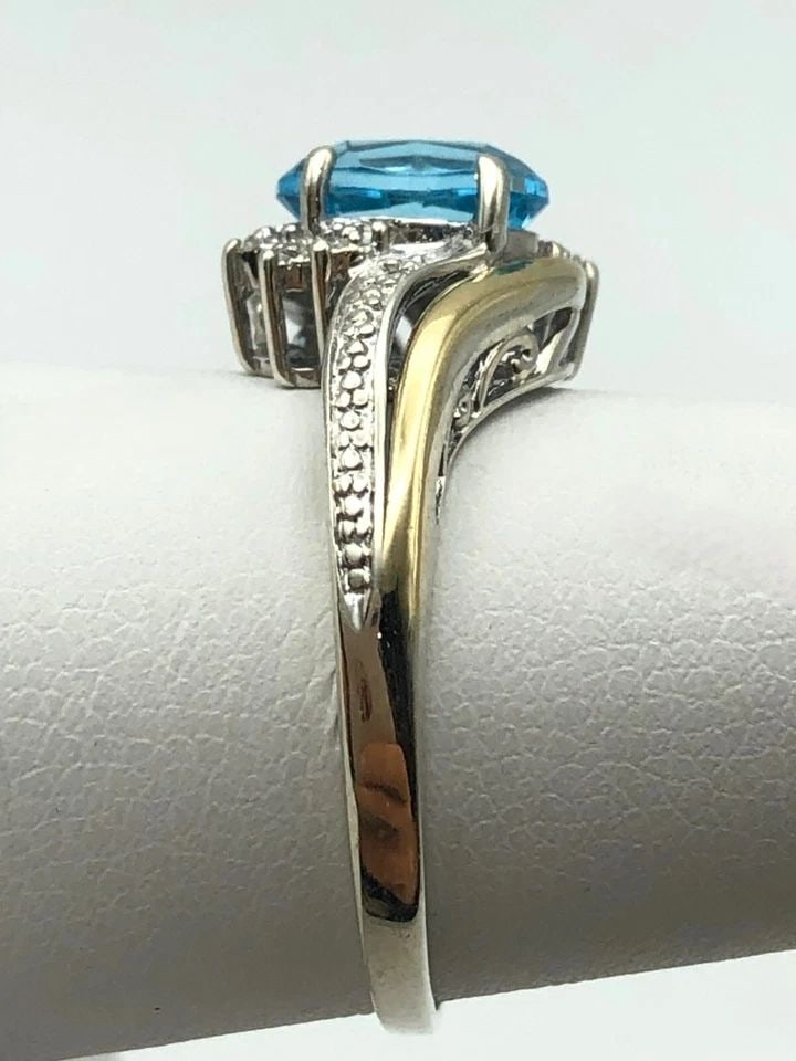 SILVER RING, 10K GOLD SIDES, BLUE TOPAZ, 0.01CTS OF DIAMONDS ( SIZE: 7.25 ) 2.8G: Silver Ring, 10k Gold accents, Blue Topaz and 0.01cts of Diamonds Condition: Used Material: 925 Sterling Silver / 10k Yellow Gold Ring Size: 7.25 Weight: 2.8 grams Top Width: 11mm Bottom Width: 1.6mm 