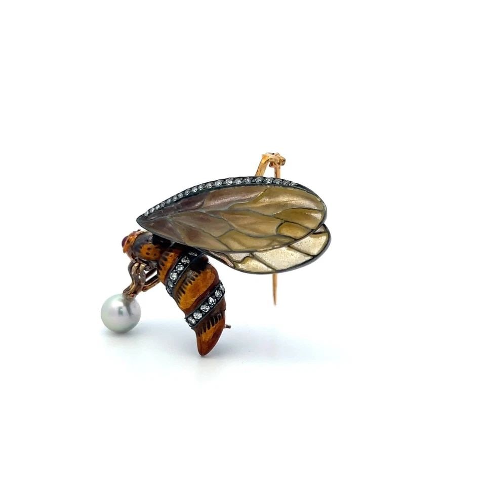 VINTAGE 18 KARAT YG BEE PIN BROOCH WITH 0.27 CARAT DIAMOND AND 6.8MM PEARL: VINTAGE 18 KARAT YG BEE PIN BROOCH WITH 0.27 CARAT DIAMOND AND 6.8MM PEARL Detailed Description: Elevate your style with this vintage bee brooch, expertly crafted in 18 Karat Yellow Gold. Sparkling wi