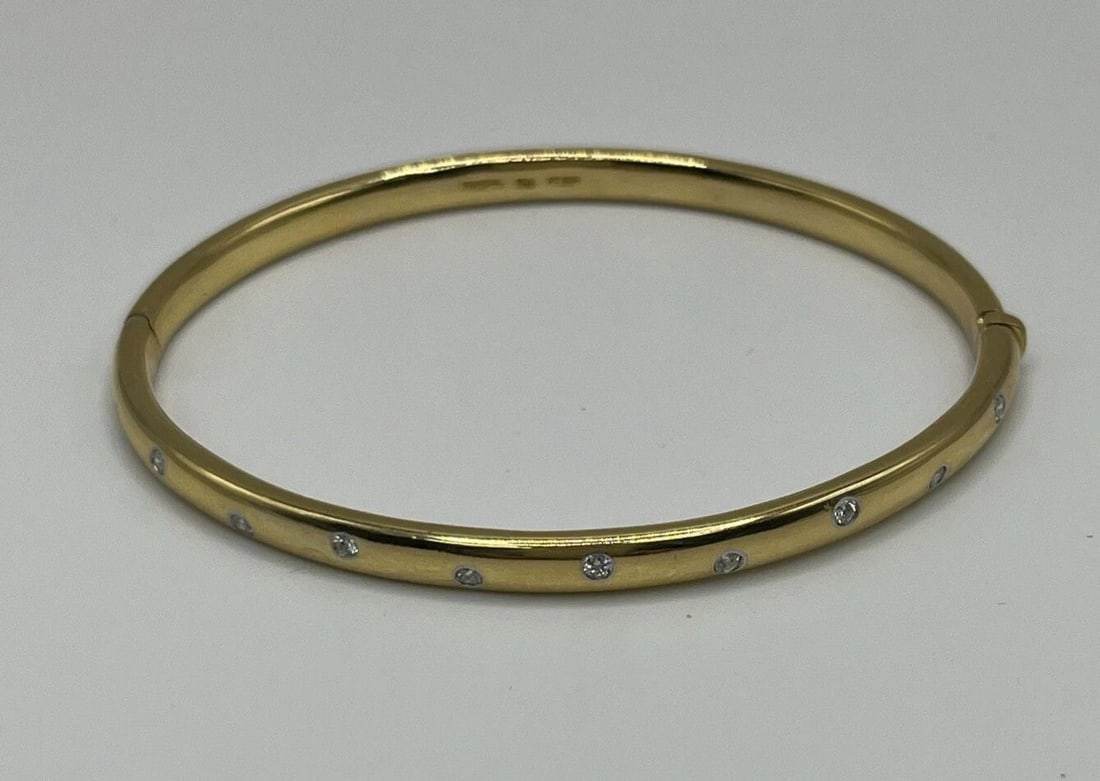 TIFFANY & CO. 18K YELLOW GOLD PLATINUM DIAMOND ETOILE BANGLE BRACELET: TIFFANY & CO. 18K YELLOW GOLD PLATINUM DIAMOND ETOILE BANGLE BRACELET TIFFANY & CO. 18K YELLOW GOLD PLATINUM DIAMOND ETOILE BANGLE BRACELET This exquisite bangle bracelet from Tiffany & Co. is a s