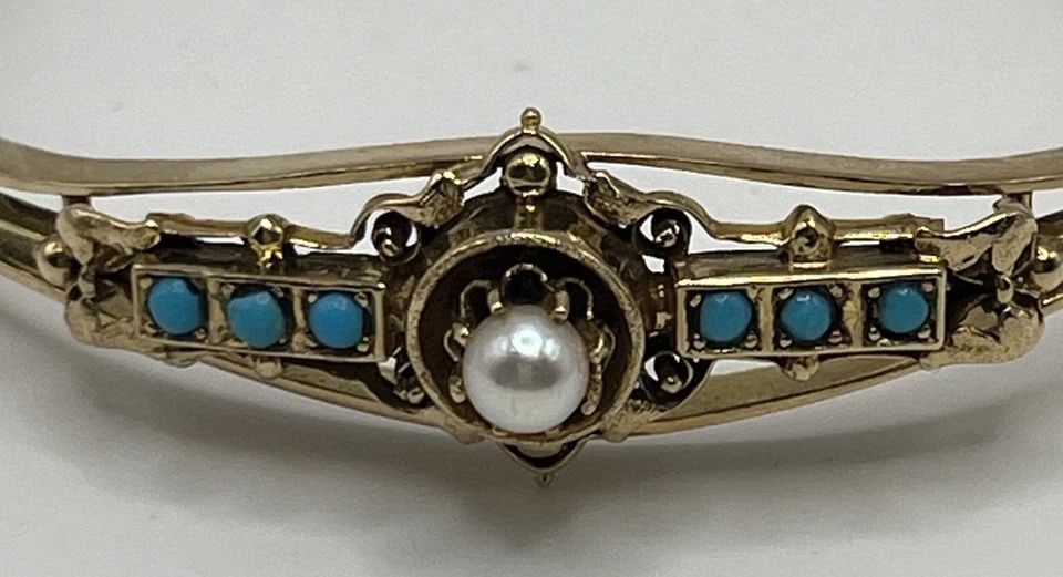14 KT YELLOW GOLD BANGLE WITH 6 TURQUOISE STONES & 1 PEARL 14.7 GRAMS: 14 KT YELLOW GOLD BANGLE WITH 6 TURQUOISE STONES & 1 PEARL 14.7 GRAMS 14 KT YELLOW GOLD BANGLE WITH 6 TURQUOISE STONES & 1 PEARL 14.7 GRAMS Add a touch of elegance to your jewelry collection with this