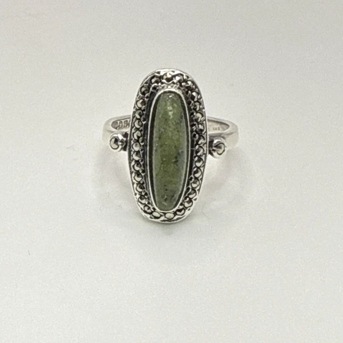 STERLING SILVER, MARCASITE, AND GREEN STONE RING SIZE 5: STERLING SILVER, MARCASITE, AND GREEN STONE RING SIZE 5 This sterling silver ring features a marcasite and green stone, making it a unique and stylish addition to any jewelry collection. The ring is c