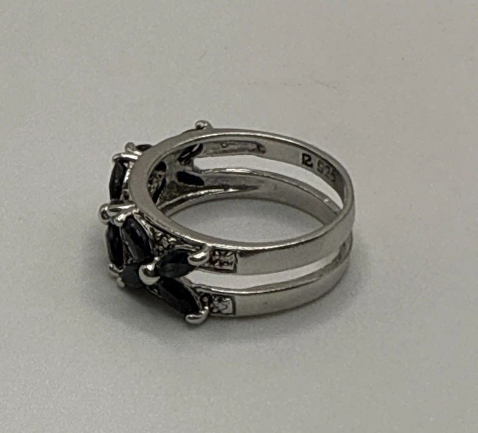 STERLING SILVER RING WITH BLACK STONES SIZE 5: STERLING SILVER RING WITH BLACK STONES SIZE 5 This sterling silver ring with black stones, size 5, is a stunning piece of fine jewelry. The black stones serve as the main focal point of the ring, addi