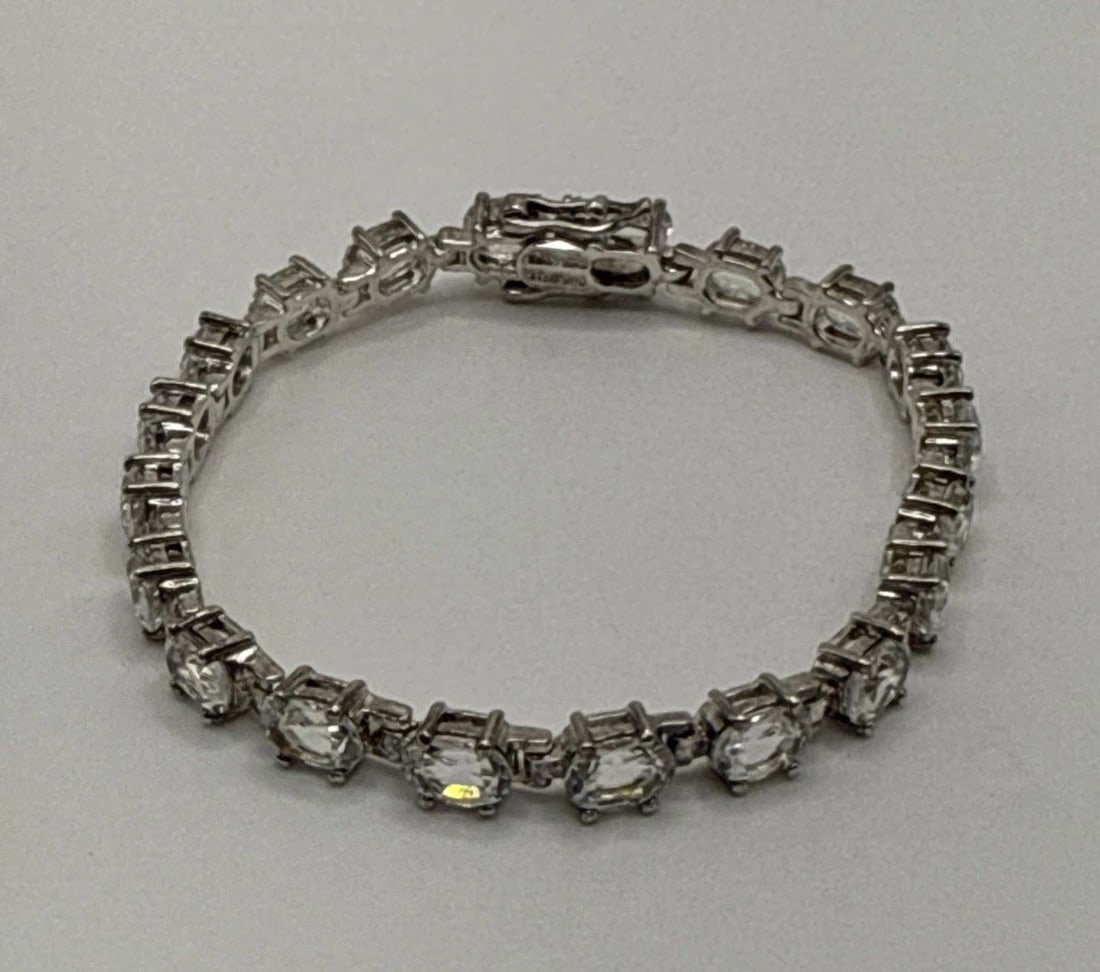 STERLING SILVER WITH COLORLESS STONES 7.5" BRACELET: STERLING SILVER WITH COLORLESS STONES 7.5" BRACELET 17.4 grams This Sterling Silver 7.5" Bracelet features a classic tennis style design with colorless stones set in 925 sterling silver. The elegant a
