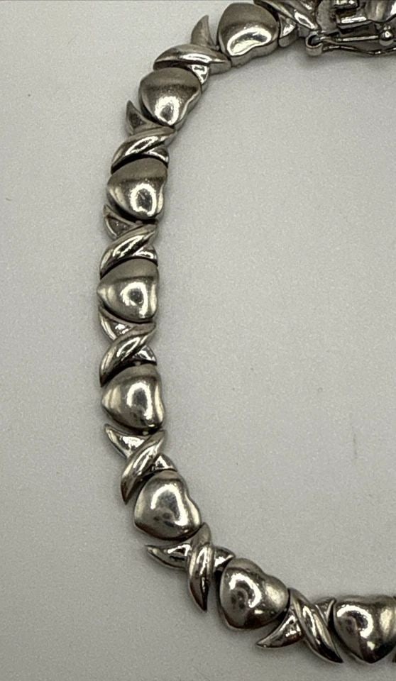 STERLING SILVER 7" X & HEART BRACELET 15.3 GRAMS: STERLING SILVER 7" X & HEART BRACELET 15.3 GRAMS This product is a stylish Sterling Silver X and Heart Bracelet, weighing 15.3 grams. The bracelet features a chain style design with a sterling silver 