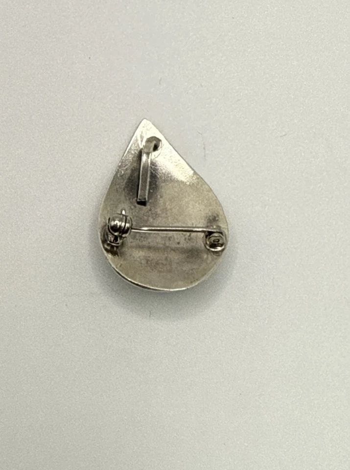 STERLING SILVER & TURQUOISE PIN/PENDANT 4.7 GRAMS: STERLING SILVER & TURQUOISE PIN/PENDANT 4.7 GRAMS This product is a sterling silver pendant featuring a beautiful turquoise stone, showcasing a vibrant blue color. The pendant is crafted with 925 ster
