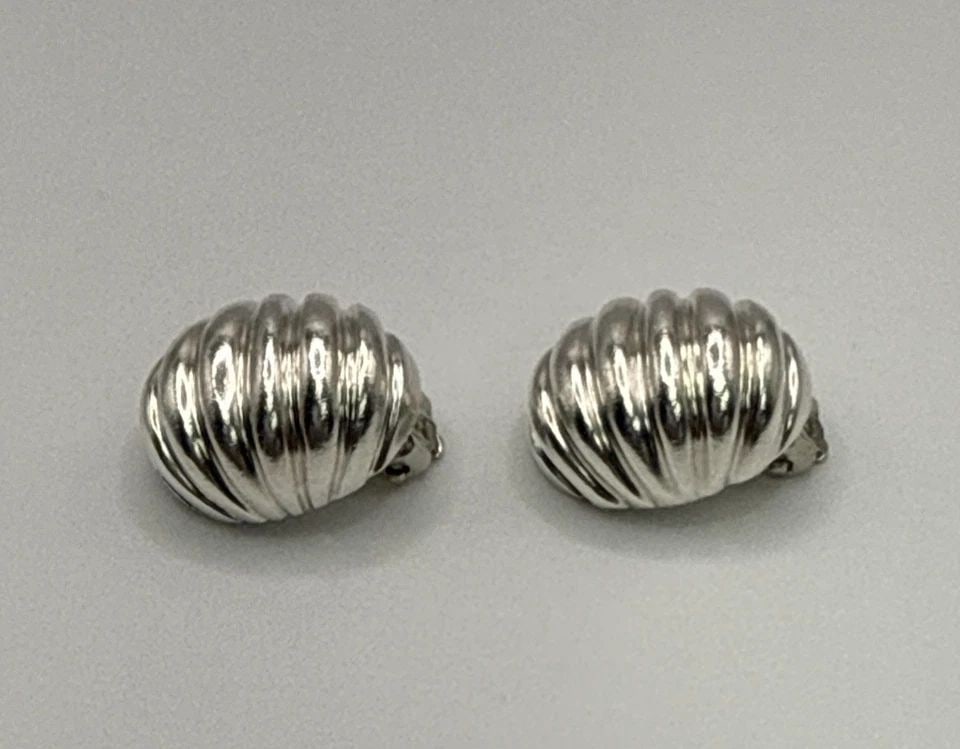 STERLING SILVER RIDGED CLIP-ON EARRINGS These Sterling Silver Ridged Clip-On Earrings feature a: These Sterling Silver Ridged Clip-On Earrings feature a classic stud style with a sleek silver color and a secure clip-on closure. Crafted from high-quality 925 sterling silver, these earrings offer a
