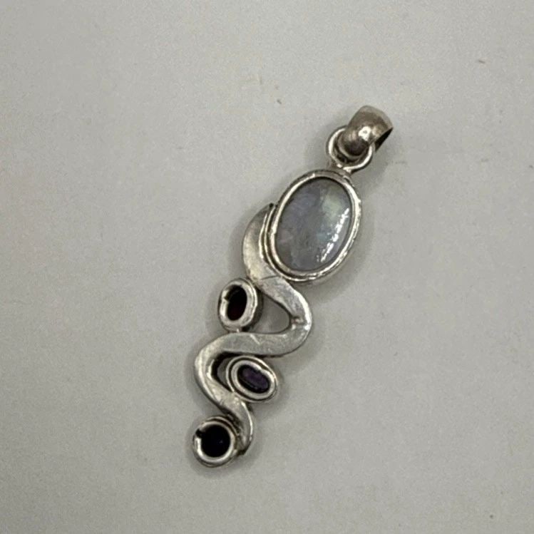 STERLING SILVER MOONSTONE PENDANT WITH 3 ADDITIONAL STONES: STERLING SILVER MOONSTONE PENDANT WITH 3 ADDITIONAL STONES This pendant is crafted from high-quality 925 sterling silver, featuring a beautiful moonstone as the main stone. The subtle elegance of the 