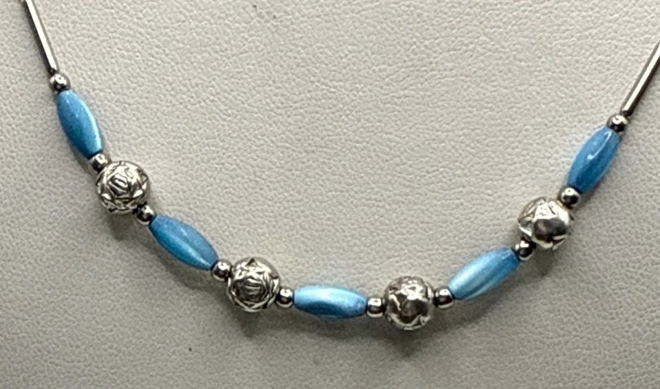 SILVER & TURQUOISE NECKLACE 17": SILVER & TURQUOISE NECKLACE 17" This Silver & Turquoise Necklace features a beautiful blue turquoise stone set in a silver beaded design. The necklace is 17 inches long and showcases the vibrant blue 