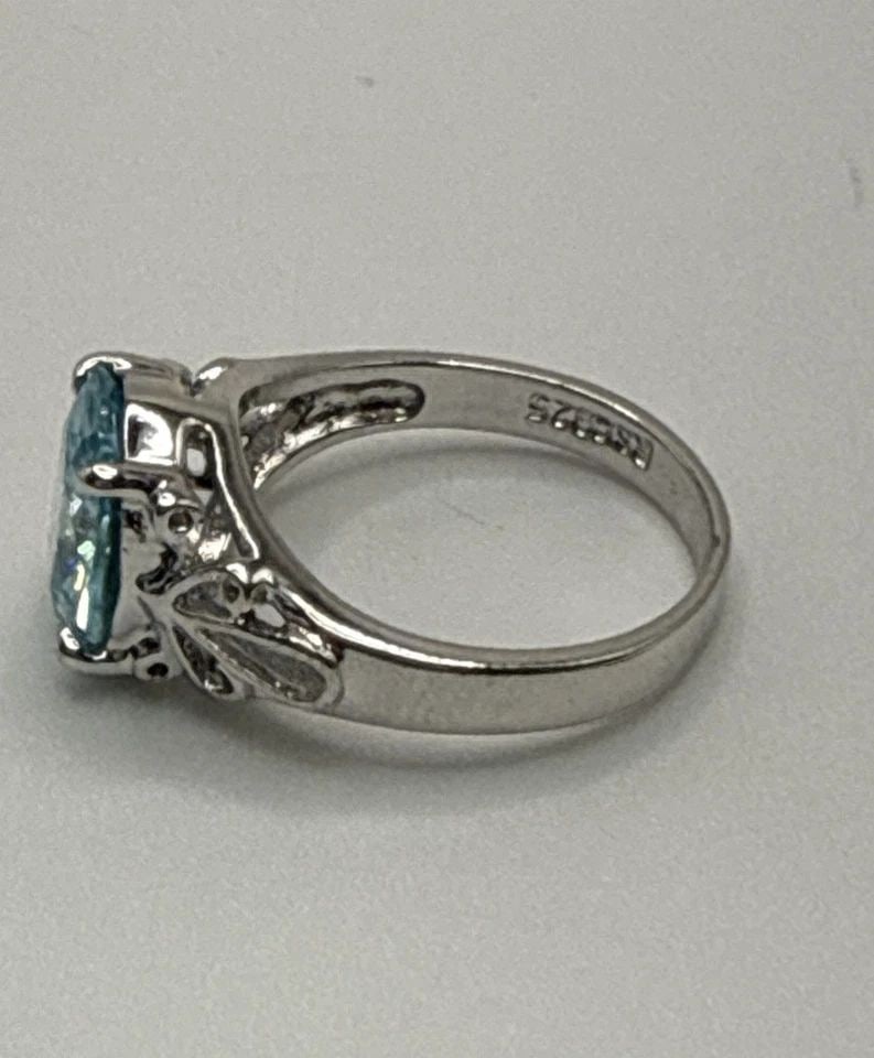 STERLING SILVER RING WITH BLUE OVAL STONE SIZE 5: STERLING SILVER RING WITH BLUE OVAL STONE SIZE 5 This sterling silver ring with a blue oval stone, size 5, is a beautiful piece of fine jewelry. The elegant design features a vibrant blue stone set in