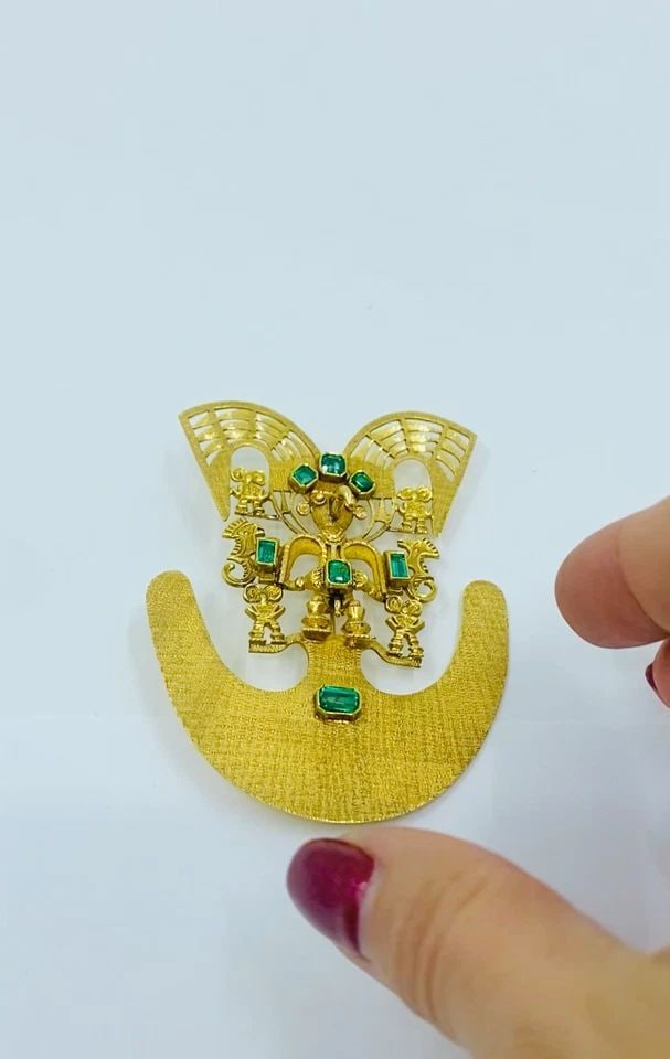 18K GOLD BROOCH/PENDANT EMERALDS PRE-COLUMBIAN JEWELRY: 18K GOLD BROOCH/PENDANT EMERALDS PRE-COLUMBIAN JEWELRY Product details: CIRCA: Late 20th Century MATERIALS: 18k Gold GEMSTONE: Emerald WEIGHT: 40 Grams MEASUREMENTS: 2 5/16" x 3" HALLMARKS: 18K ITEM D