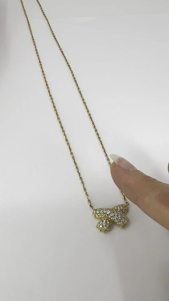 VINTAGE FRED PARIS 18K GOLD DIAMOND RIBBON NECKLACE: VINTAGE FRED PARIS 18K GOLD DIAMOND RIBBON NECKLACE This vintage Fred Paris necklace features a pavé diamond ribbon pendant set in 18k yellow gold. The pendant measures 7/8" in length and 1/2" in hei