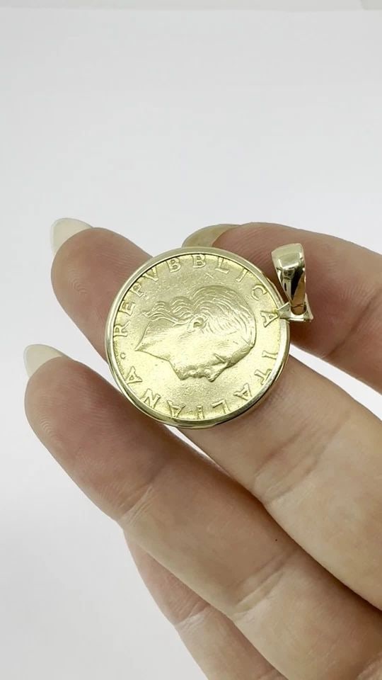 ITALIAN 14K GOLD LIRE COIN PENDANT: ITALIAN 14K GOLD LIRE COIN PENDANT This vintage Italian pendant features an authentic 1978 200 Lire coin, set in a finely crafted 14K yellow gold bezel by Milor. The coin itself is composed of aluminu