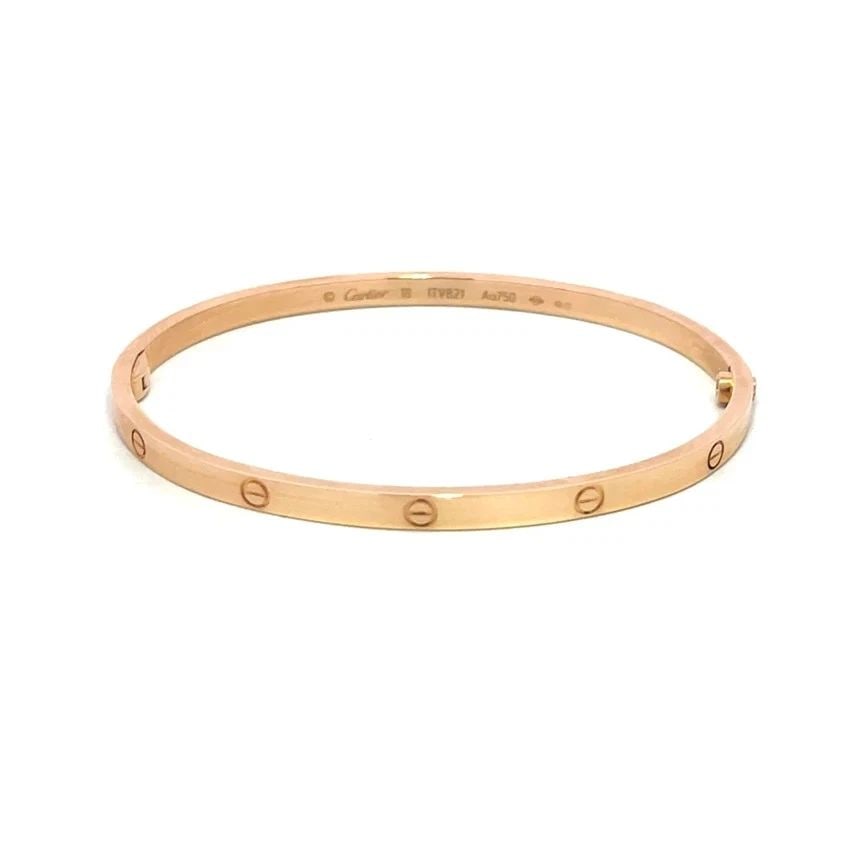 CARTIER LOVE GOLD BANGLE SMALL MODEL 18K ROSE SIZE 18 BOX & CERTIFICATE: CARTIER LOVE GOLD BANGLE SMALL MODEL 18K ROSE SIZE 18 BOX & CERTIFICATE This elegant bangle is by Cartier, from 18k rose gold, it features a screw closure and signed by the brand. This small model ban