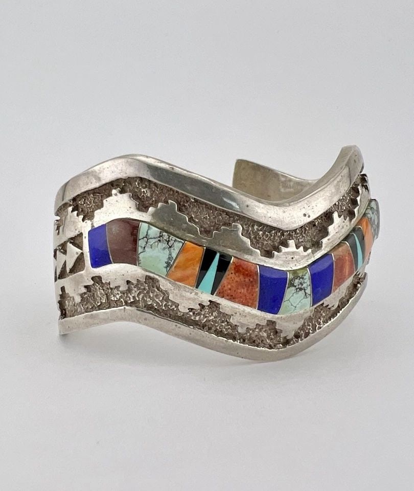 CALVIN BEGAY NAVAJO STERLING FLUSH MULTI GEMS OVERLAY WAVE CUFF BRACELET 74.8G: Calvin Begay Navajo Sterling Flush Multi Gems Overlay Wave Cuff Bracelet 74.8g Cuff is Around 5 1/4" tip to Tip and has a 1 1/4" Wide Gap Cuff Is 1 1/8" Wide In the Center Weight is 74.8 Grams on my s