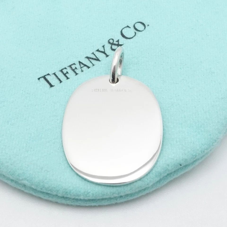TIFFANY & CO. STERLING SILVER BLANK OVAL TAG PENDANT 1.25": Tiffany & Co. Sterling Silver Blank Oval Tag Pendant ONLY Total Height - 1.25" Pendant Width - 0.75" Depth - 1mm Thick Bail Height - 5mm Bail Width - 4mm Total Weight - 5.8 Grams Pouch NOT Included
