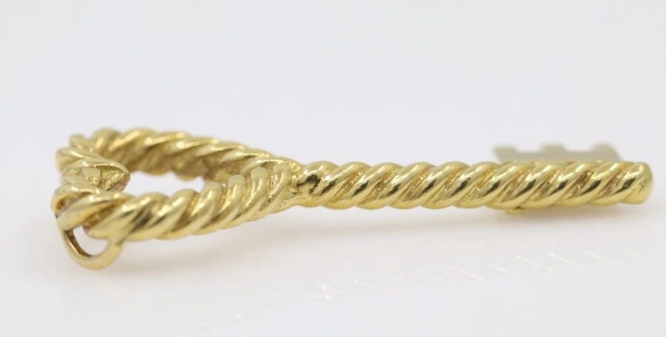 TIFFANY & CO. 18K YELLOW GOLD TWIST HEART KEY PENDANT 7.2 GRAMS: TIFFANY & CO. 18K YELLOW GOLD TWIST HEART KEY PENDANT 7.2 GRAMS Description Tiffany & Co. 18K Yellow Gold Twist Heart Key Pendant Pendant is in good condition. May show signs of wear. APPROXIMATE MEAS
