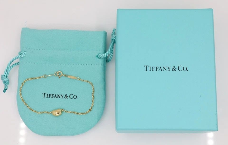 TIFFANY & CO. ELSA PERETTI 18K YELLOW GOLD BEAN BRACELET: TIFFANY & CO. ELSA PERETTI 18K YELLOW GOLD BEAN BRACELET Description Tiffany & Co. Elsa Peretti 18K Yellow Gold Bean Bracelet Bracelet is in good condition. May show signs of wear. APPROXIMATE MEASURE