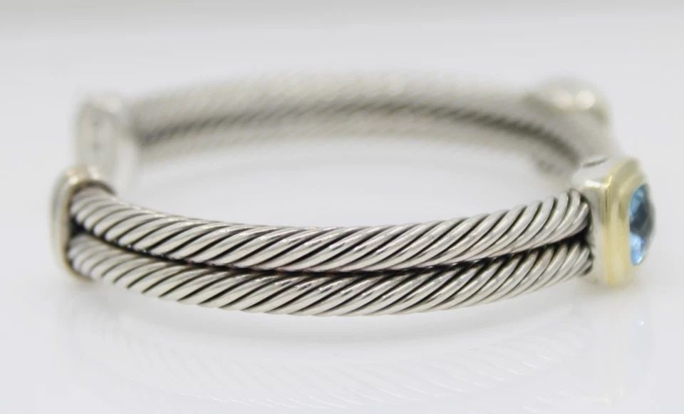 DAVID YURMAN STERLING SILVER & 18K GOLD BLUE TOPAZ ALBION STATION CUFF BRACELET: DAVID YURMAN STERLING SILVER & 18K GOLD BLUE TOPAZ ALBION STATION CUFF BRACELET Description David Yurman Sterling Silver & 18K Yellow Gold Blue Topaz Albion Double Station Cuff Bracelet Bracelet is in