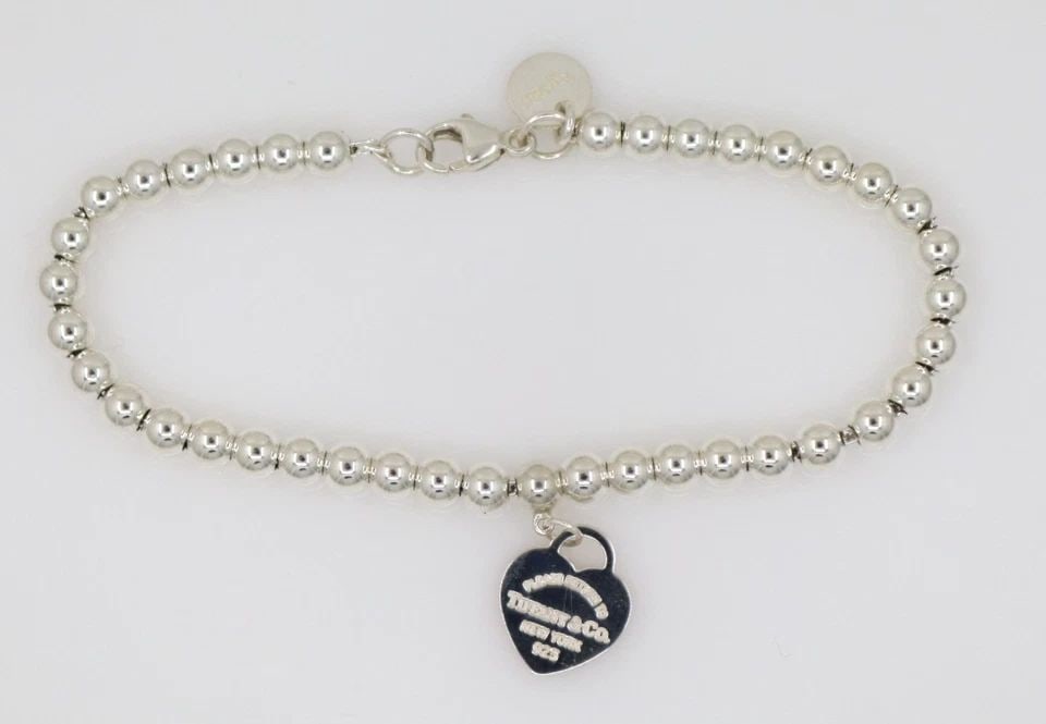 TIFFANY & CO. STERLING SILVER PINK HEART ENAMEL TAG 4MM BEAD BRACELET: TIFFANY & CO. STERLING SILVER PINK HEART ENAMEL TAG 4MM BEAD BRACELET Description Tiffany & Co. Return to Tiffany Pink Enamel Heart Tag Beaded Bracelet Bracelet is in good condition. May show signs of