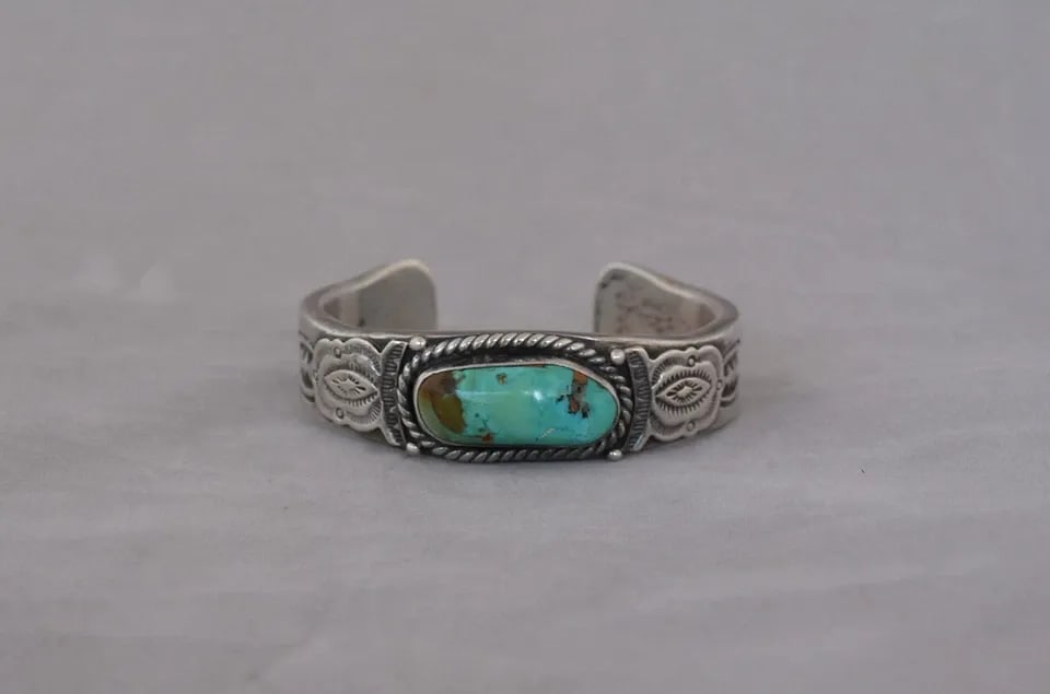 JOHN NELSON - VTG HEAVY NAVAJO HANDSTAMPED SILVER TURQUOISE BRACELET - 7" MENS: JOHN NELSON - VTG HEAVY NAVAJO HANDSTAMPED SILVER TURQUOISE BRACELET - 7" MENS This vintage bracelet has been beautifully crafted by Navajo silversmith John Nelson. The sterling silver band is 1/8" th