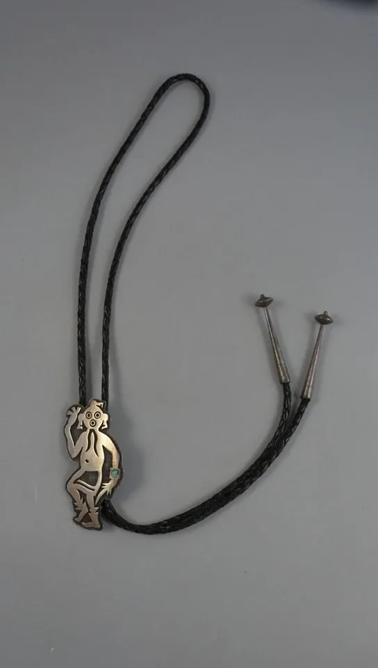 LARRY POLIVEMA - VINTAGE HOPI INDIAN SILVER BOLO TIE - MUDHEAD WITH TURQUOISE: LARRY POLIVEMA - VINTAGE HOPI INDIAN SILVER BOLO TIE - MUDHEAD WITH TURQUOISE This vintage sterling silver bolo tie has been beautifully crafted by Hopi silversmith Larry Polivema. It shows a Mudhead 