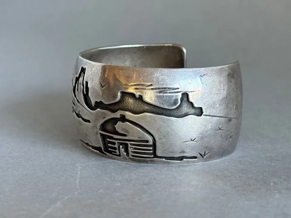 VINTAGE NAVAJO STERLING SILVER STORYTELLER BRACELET SIGNED DM: VINTAGE NAVAJO STERLING SILVER STORYTELLER BRACELET SIGNED DM Vintage Navajo Sterling Silver Storyteller Bracelet Hogan Signed DM ..1 1/4" wide .. 5 1/4" Around Inside ..With a 1 1/4" Opening ..54 Gra