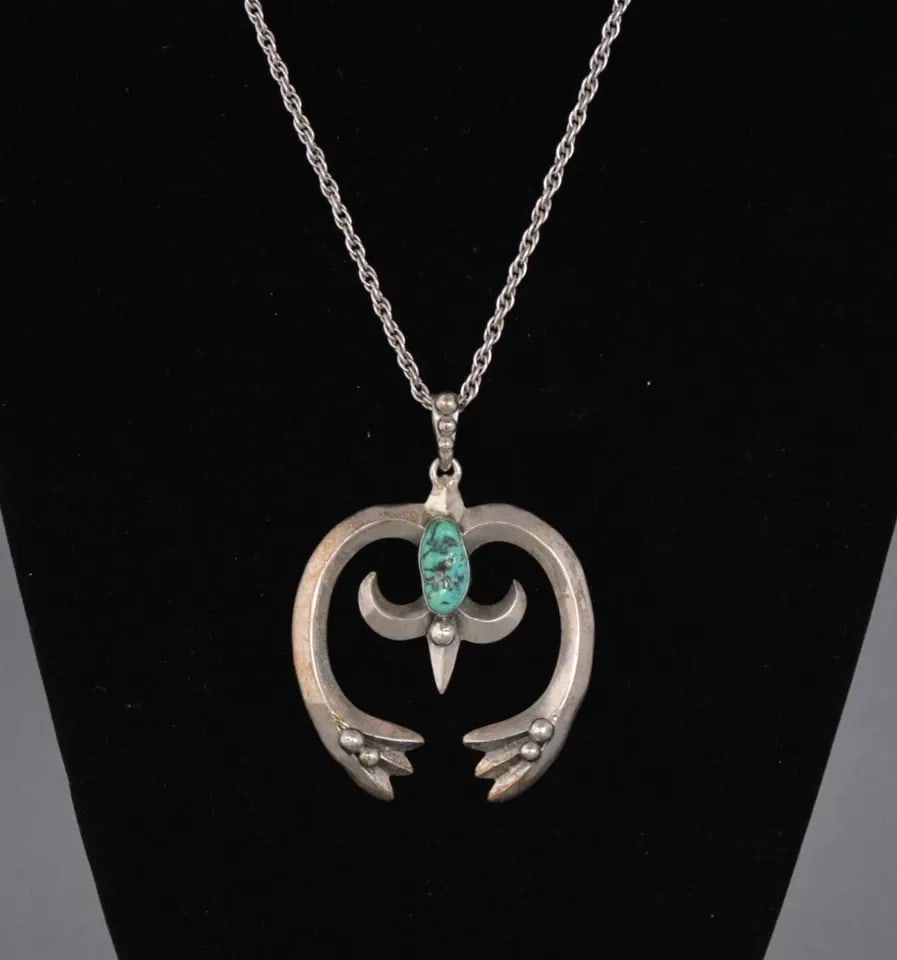 VINTAGE NAVAJO CAST STERLING SILVER NAJA PENDANT WITH TURQUOISE ON CHAIN: VINTAGE NAVAJO CAST STERLING SILVER NAJA PENDANT WITH TURQUOISE ON CHAIN This Navajo naja pendant has been beautifully cast in silver and set with a turquoise stone. It is on a 19.5" chain. The naja h
