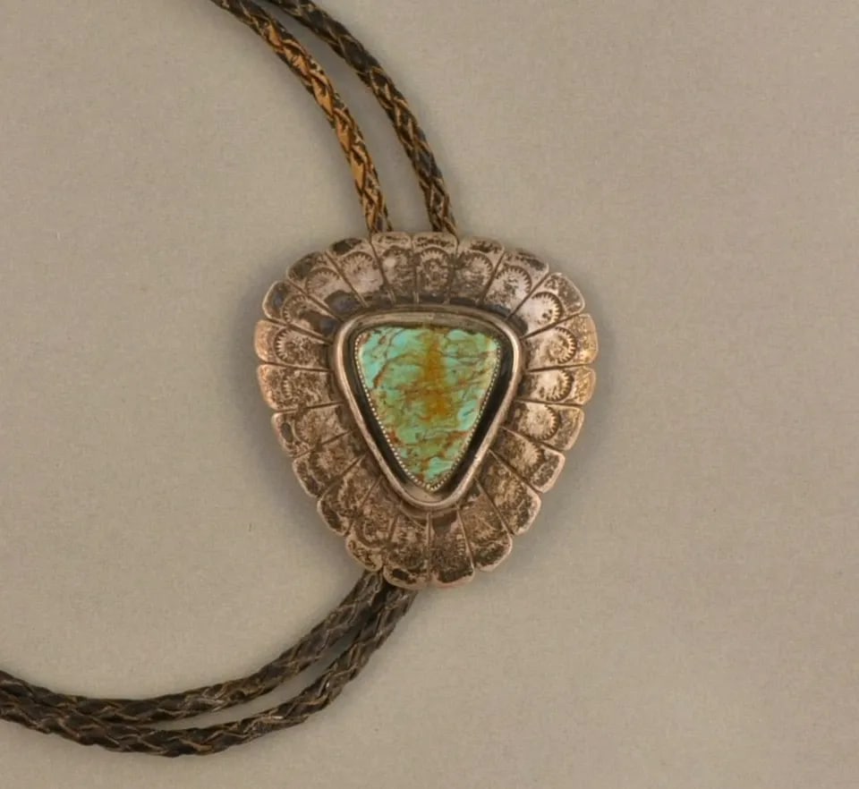 OLD PAWN NAVAJO STERLING SILVER BOLO TIE - LARGE TURQUOISE - HANDSTAMPED SUNRAYS: OLD PAWN NAVAJO STERLING SILVER BOLO TIE - LARGE TURQUOISE - HANDSTAMPED SUNRAYS This old pawn sterling silver bolo tie has a large turquoise stone surrounded with hand stamped chiseled sunrays. The b