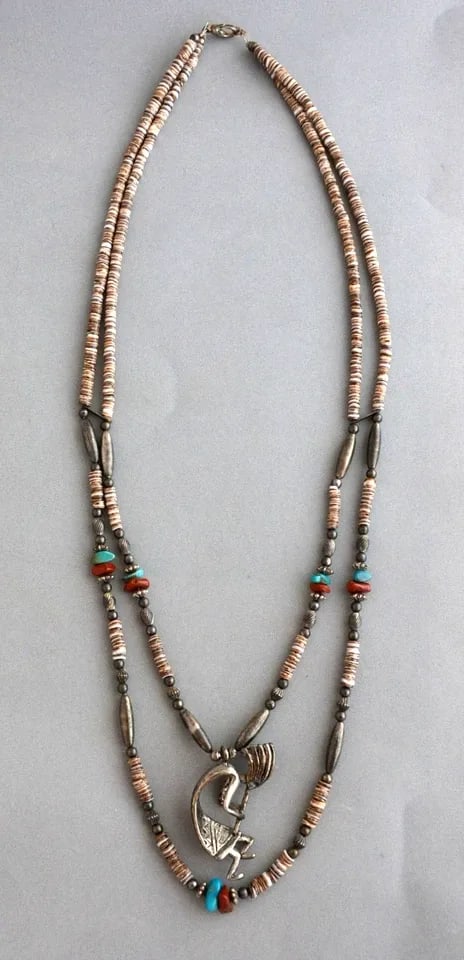 NAVAJO DOUBLE STRAND NECKLACE - CLAMSHELL HEISHI TURQUOISE CORAL & FLUTE PLAYER: NAVAJO DOUBLE STRAND NECKLACE - CLAMSHELL HEISHI TURQUOISE CORAL & FLUTE PLAYER This double strand Navajo necklace has clamshell heishi with turquoise, coral and silver beads. At the center is a 3 dim