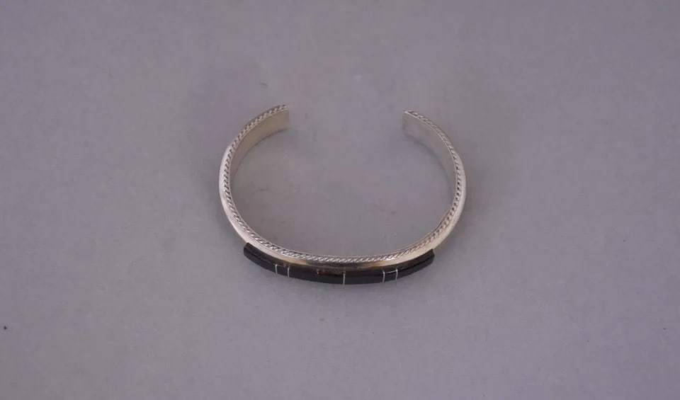 FRANCE YAZZIE - NAVAJO STERLING SILVER BRACELET - BROWN ONYX INLAY - SZ 6 1/4": FRANCE YAZZIE - NAVAJO STERLING SILVER BRACELET - BROWN ONYX INLAY - SZ 6 1/4" This bracelet came out of the inventory of a trading post that closed in Sedona, Arizona. It still has the original tags 