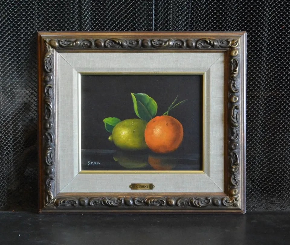 ANTONIO GUSINI (1901-) VINTAGE STILL LIFE OIL PAINTING - FRUIT - FRAMED: ANTONIO GUSINI (1901-) VINTAGE STILL LIFE OIL PAINTING - FRUIT - FRAMED This realistic still life oil painting of a lime and tangerine was done by Italian artist Antonio Gusini. It is oil on canvas. I