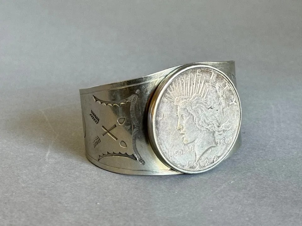 OLD PAWN NAVAJO NICKEL SILVER BRACELET WITH SILVER DOLLAR COIN 1922: OLD PAWN NAVAJO NICKEL SILVER BRACELET WITH SILVER DOLLAR COIN 1922 Old Pawn Navajo Nickel Silver Bracelet Stamped with Silver Dollar Coin. 1922 ..1 1/2 Tall 5 1/4 " Inside with a 1 1/8 " Opening ..
