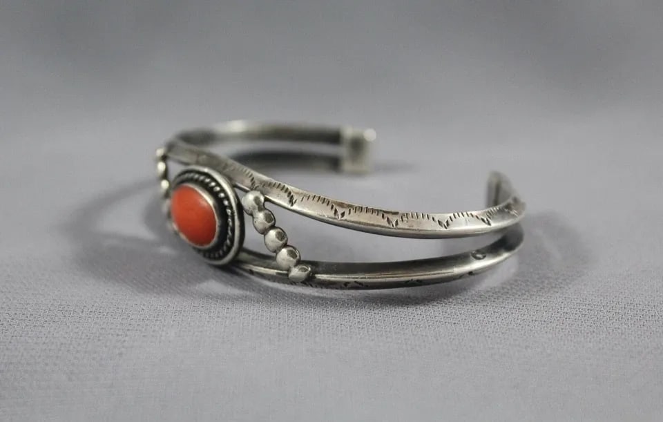 OLD PAWN NAVAJO STERLING SILVER AND CORAL BRACELET: OLD PAWN NAVAJO STERLING SILVER AND CORAL BRACELET Item Description: This bracelet measures 1/2 " wide at the center front. The size is 5" around the inside with an additional 1 1/4" opening at the ba