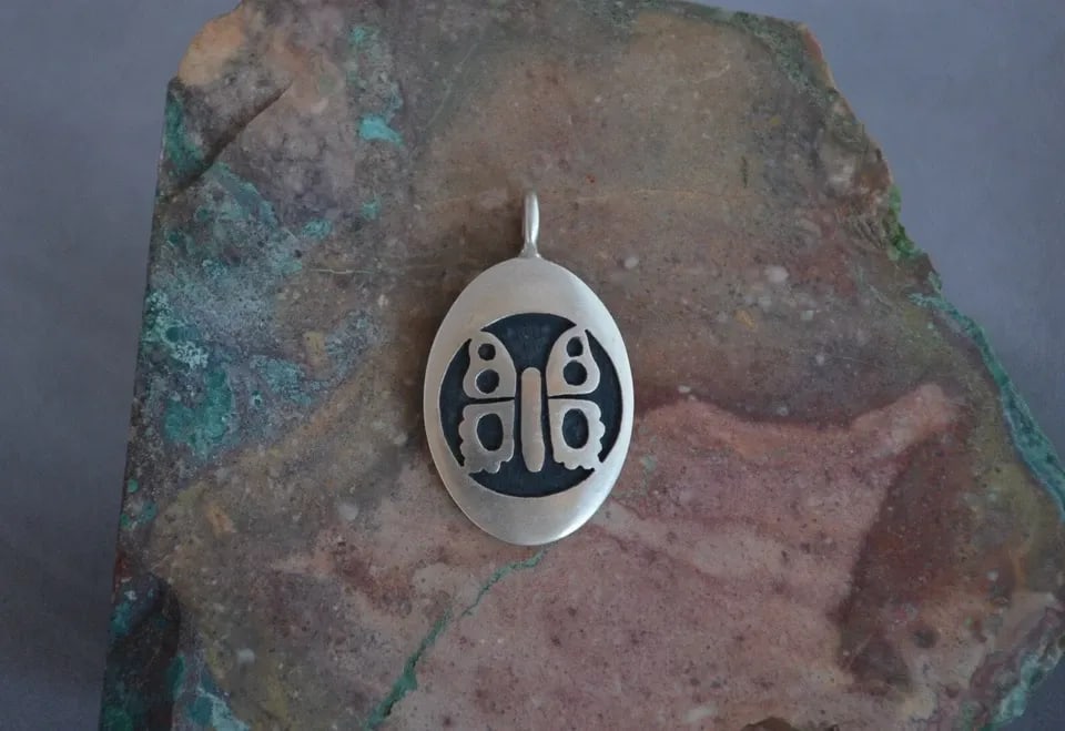 MANUEL HOYUNGOWA (1953-2011 - HOPI STERLING SILVER OVAL PENDANT BUTTERFLY - 1.5": MANUEL HOYUNGOWA (1953-2011 - HOPI STERLING SILVER OVAL PENDANT BUTTERFLY - 1.5" This sterling silver pendant has been beautifully crafted by the Hopi artists Manuel and Karen Hoyungwa. The pendant sh