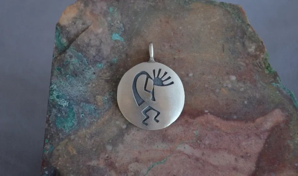 MANUEL HOYUNGOWA (1953-2011) - HOPI SILVER ROUND PENDANT - FLUTE PLAYER - 1.25": MANUEL HOYUNGOWA (1953-2011) - HOPI SILVER ROUND PENDANT - FLUTE PLAYER - 1.25" This sterling silver pendant has been beautifully crafted by the Hopi artists Manuel and Karen Hoyungwa. The pendant sho
