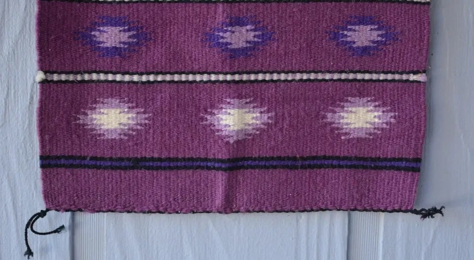 VINTAGE NAVAJO RUG - MAGNETA GROUND W WHITE LILAC PURPLE GEOMETRICS - 21" X 16": VINTAGE NAVAJO RUG - MAGNETA GROUND W WHITE LILAC PURPLE GEOMETRICS - 21" X 16" This vintage Navajo rug has a very unique color combination with serrated diamonds in a banded design. It measures 21" x
