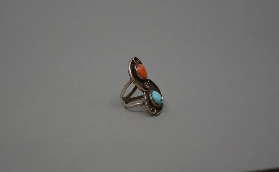 VINTAGE NAVAJO STERLING SILVER RING - TURQUOISE CORAL - SIZE 5 - 1.5" TALL: VINTAGE NAVAJO STERLING SILVER RING - TURQUOISE CORAL - SIZE 5 - 1.5" TALL This vintage Navajo has a turquoise and coral stone set into a curved accented with silver wire and a raindrop bead at the ce