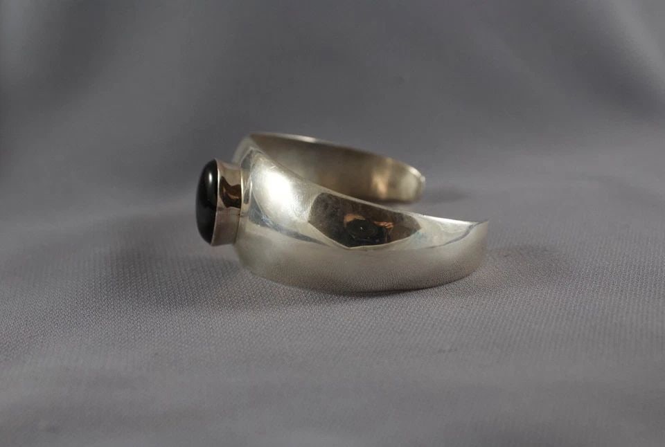 NAVAJO STERLING AND ONYX BRACELET: NAVAJO STERLING AND ONYX BRACELET Item Description: 1" Wide 5 3/8 " Inside with a 1 1/4 " Opening P