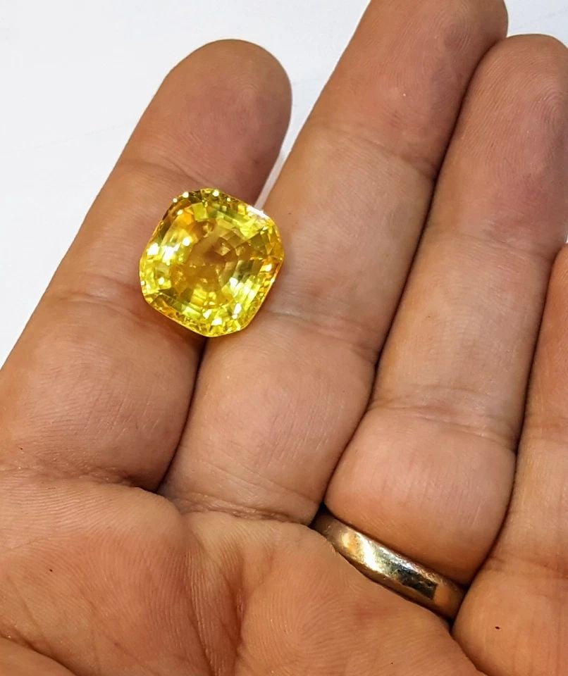 20.12CT. NATURAL YELLOW SAPPHIRE LOOSE GEMSTONE CUSHION: 20.12CT. NATURAL YELLOW SAPPHIRE LOOSE GEMSTONE CUSHION This stunning cushion-cut yellow sapphire is a truly natural gemstone, with a total carat weight of 20.12. The gemstone boasts a very good cut g