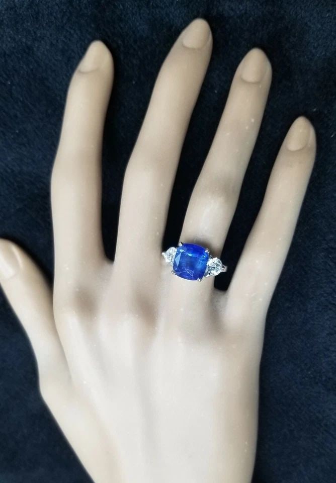VINTAGE 14K WHITE GOLD ENGAGEMENT RING 4.88CT NATURAL CUSHION BLUE SAPPHIRE GIA: VINTAGE 14K GOLD ENGAGEMENT RING 4.88CT CUSHION SHAPE BLUE SAPPHIRE GIA CERT This vintage engagement ring features a stunning 4.88ct cushion-shaped blue sapphire set in a three-stone setting with two 