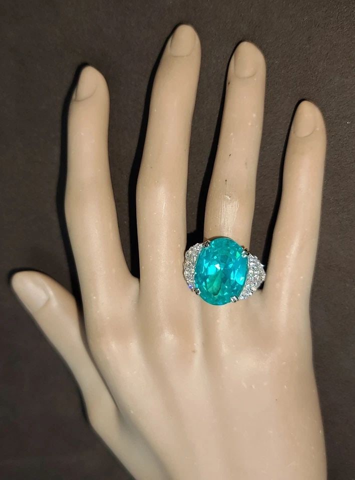 14K WHITE YELLOW GOLD COCKTAIL RING 16.53CT. NEON BLUE OVAL TOURMALINE DIAMOND: 14K WHITE YELLOW GOLD COCKTAIL RING 16.53CT. LAB GROWN PARAIBA TOURMALINE OVAL This 14K white gold cocktail ring features a stunning 16.53CT lab-grown Paraiba Tourmaline with an oval cut, accented wit